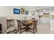 Dining area with wood table, chairs, and art on the wall, leading to the kitchen at 7430 Sunshine Skyway S Ln # 402, St Petersburg, FL 33711
