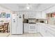 Bright kitchen featuring white cabinets, modern appliances, and a stylish backsplash at 7430 Sunshine Skyway S Ln # 402, St Petersburg, FL 33711