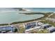 Scenic aerial view of waterfront apartment buildings, a nearby beach, and lush landscaping at 9 Forbes Pl # 504, Dunedin, FL 34698