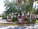 Street view of stone and brick entrance sign into Dunedin community featuring lush green landscaping at 9 Forbes Pl # 504, Dunedin, FL 34698