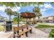 Outdoor pavilion with a grill, benches, brick pathway, and tropical plants at 9 Forbes Pl # 504, Dunedin, FL 34698
