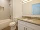 Well-lit bathroom featuring a granite countertop, tiled shower, and white cabinets at 9002 Glenarm Way, Spring Hill, FL 34613