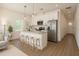 Modern kitchen features stainless steel appliances, island with bar seating, and bright natural light at 9002 Glenarm Way, Spring Hill, FL 34613