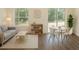 Inviting living room with large windows, wood floors, neutral tones, and access to outdoor space at 9002 Glenarm Way, Weeki Wachee, FL 34613