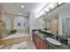 Modern bathroom showcasing double vanity, soaking tub, and spacious glass shower for a spa-like experience at 1038 Bellasol Way # 202, Apollo Beach, FL 33572
