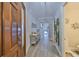 Bright, open hallway with wood-look tile flooring, stylish decor, and access to rooms at 1038 Bellasol Way # 202, Apollo Beach, FL 33572