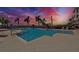 Beautiful pool with tropical landscaping under a colorful sunset sky at 1038 Bellasol Way # 202, Apollo Beach, FL 33572