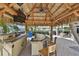 Outdoor tiki bar featuring a tv, ceiling fan, bar seating, and cooking area at 1038 Bellasol Way # 202, Apollo Beach, FL 33572