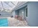 View of the screened-in patio with table and chairs in backyard with pool at 12037 Conway St, Spring Hill, FL 34609