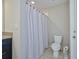 Well-maintained bathroom featuring tile flooring, toilet, and a shower with a stylish shower curtain at 12037 Conway St, Spring Hill, FL 34609