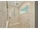 Tiled bathroom featuring a tiled shower stall with seating and a built in shelf at 12037 Conway St, Spring Hill, FL 34609