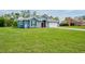 Charming home featuring a well-manicured lawn, lovely landscaping, and a welcoming red front door at 12037 Conway St, Spring Hill, FL 34609