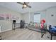 Upstairs game room including a ceiling fan, gray sofa, and workstation with dual monitors at 12037 Conway St, Spring Hill, FL 34609