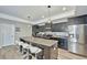 Modern kitchen with granite counters, stainless steel appliances, dark wood cabinets and island with seating at 12037 Conway St, Spring Hill, FL 34609