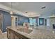 Open kitchen featuring a large island with granite countertops and modern stainless steel sink at 12037 Conway St, Spring Hill, FL 34609