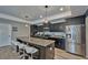 Modern kitchen with granite counters, stainless steel appliances, dark wood cabinets and island with seating at 12037 Conway St, Spring Hill, FL 34609