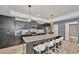 Modern kitchen with a large island, granite countertops, dark cabinetry, stainless steel appliances, and modern pendant lighting at 12037 Conway St, Spring Hill, FL 34609