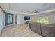 Cozy living room with large TV, ceiling fan, and sliding glass doors to the backyard at 12037 Conway St, Spring Hill, FL 34609