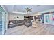 Spacious living room with a large sectional sofa, ceiling fan, and light wood flooring at 12037 Conway St, Spring Hill, FL 34609