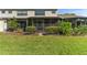 Home's backyard featuring a screened-in patio and green grass at 1205 Hounds Run, Safety Harbor, FL 34695