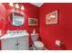 Bright half bath with white marble sink and red walls at 1205 Hounds Run, Safety Harbor, FL 34695