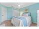 Bright bedroom with a white bed, light blue walls and carpeted floors at 1205 Hounds Run, Safety Harbor, FL 34695