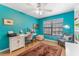 Bright bedroom with teal walls, desk, and wood flooring at 1205 Hounds Run, Safety Harbor, FL 34695