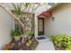 Welcoming front entrance with a cozy red awning and lush landscaping at 1205 Hounds Run, Safety Harbor, FL 34695
