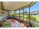 Relaxing screened-in patio with tiled floors and comfortable seating at 1205 Hounds Run, Safety Harbor, FL 34695