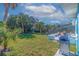 Large backyard with lush grass, tropical landscaping, and an outdoor dining area at 125 11Th Ave, Indian Rocks Beach, FL 33785