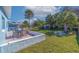 Landscaped backyard with a paver patio, dining table, stone water feature, and palm trees at 125 11Th Ave, Indian Rocks Beach, FL 33785