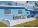 Close up of outdoor patio and dining area, attached to light blue house with large backyard at 125 11Th Ave, Indian Rocks Beach, FL 33785