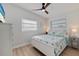 Bright bedroom featuring a ceiling fan, light wood floors and a comfortable white-framed bed with floral bedspread at 125 11Th Ave, Indian Rocks Beach, FL 33785