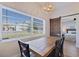 Dining room features a large window, wood table with seating for four, and a view into the bedroom at 125 11Th Ave, Indian Rocks Beach, FL 33785