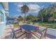 Paver patio features an outdoor dining table and landscaped views with palm trees at 125 11Th Ave, Indian Rocks Beach, FL 33785