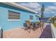Paver patio featuring an outdoor dining set for four with a blue exterior wall at 125 11Th Ave, Indian Rocks Beach, FL 33785