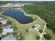 Aerial view of a lake, walking trails, a tennis court, and residential homes in the community at 12903 49Th E Ln, Parrish, FL 34219