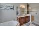 Bright bathroom with a soaking tub, granite countertop vanity, and a tiled walk-in shower at 12903 49Th E Ln, Parrish, FL 34219