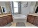 Bright bathroom view of a garden tub beneath a window, flanked by granite-topped vanities at 12903 49Th E Ln, Parrish, FL 34219