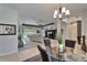 Open concept dining room and living room with contemporary chandelier and view of the cozy living room at 12903 49Th E Ln, Parrish, FL 34219