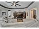 Living room with gray sectional, ceiling fan and decorative shelving next to an arched doorway at 12903 49Th E Ln, Parrish, FL 34219
