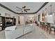 Open-concept living room with a large sectional sofa, ceiling fan, and tile flooring at 12903 49Th E Ln, Parrish, FL 34219