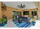 Relaxing covered patio with modern furniture, ceiling fan, and sliding glass doors to the main living area at 12903 49Th E Ln, Parrish, FL 34219