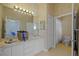 Bathroom featuring double sinks, tile flooring and a toilet and shower behind a door at 13750 Dowling Ln, Odessa, FL 33556
