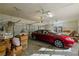 Spacious garage with a parked car and overhead storage at 13750 Dowling Ln, Odessa, FL 33556