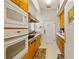 Galley kitchen featuring tiled floors, white appliances, and ample cabinetry at 13750 Dowling Ln, Odessa, FL 33556