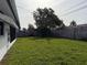 Spacious backyard featuring lush green grass and a wooden fence, offering privacy at 14264 Page Ave, Largo, FL 33774