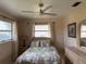 Cozy bedroom with a ceiling fan, neutral color walls, and bright natural light from windows at 14264 Page Ave, Largo, FL 33774