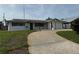 Well-maintained single-story home with a charming front yard and convenient driveway leading to an attached two-car garage at 14264 Page Ave, Largo, FL 33774