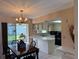 Bright kitchen featuring white cabinetry, black appliances, tile flooring, and a breakfast bar open to the dining area at 14264 Page Ave, Largo, FL 33774
